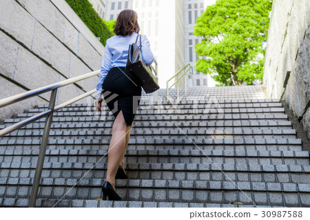 A woman ascending a staircase 30987588