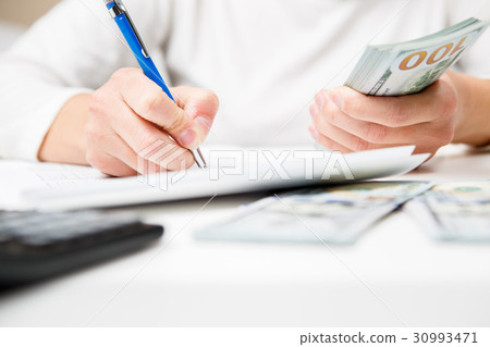 Entrepreneur calculating and reviewing investment Entrepreneur calculating and reviewing investment 30993471