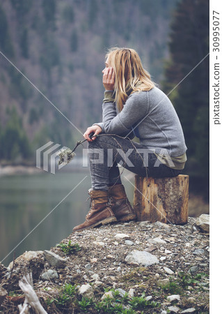 woman meditating on a lake shore 30995077