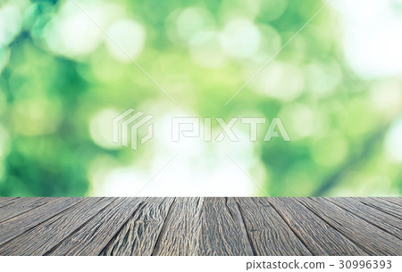 Empty wooden floor with green bokeh and sunlight 30996393