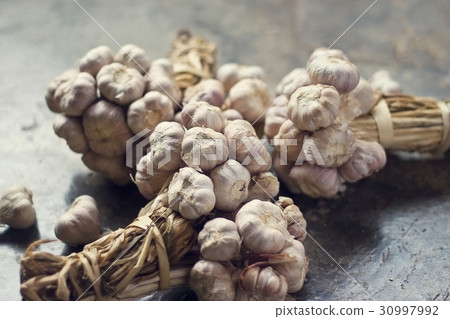 Garlic bulbs group on concrete floor, soft focus 30997992