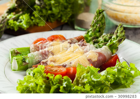 Baked green asparagus with prosciutto and cheese 30998283