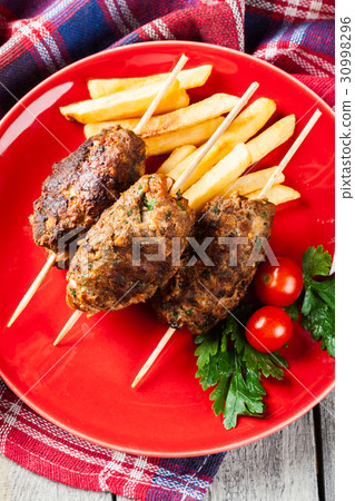 Barbecued kofta with fries on a plate 30998296