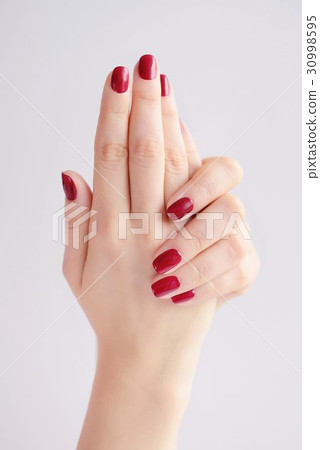 Closeup of hands of young woman with red manicure 30998595