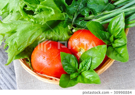 Fresh vegetables and greenery are in a basket Fresh vegetables and greenery are in a basket 30998884