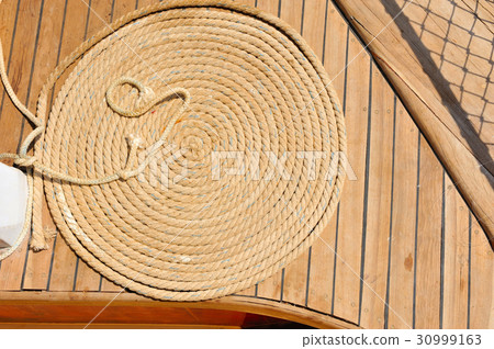 Ship ropes on a wooden boat deck 30999163