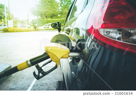 Refuel the pump in car at gas station. 31001634