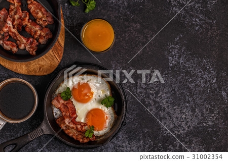 Breakfast with bacon , fried egg, coffee  31002354