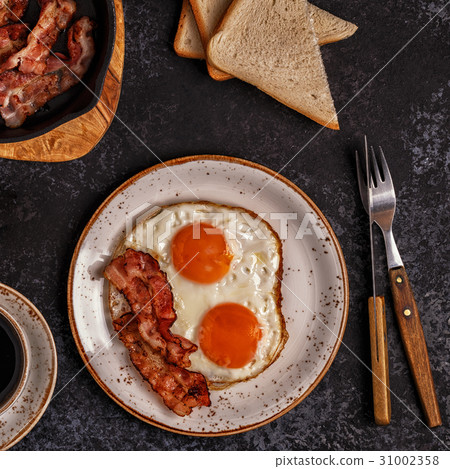 Breakfast with bacon , fried egg, coffee  31002358