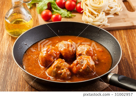 Meatballs with tomato sauce on black pan 31002957