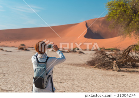 Tourist taking photo at Sossusvlei Tourist taking photo at Sossusvlei 31004274