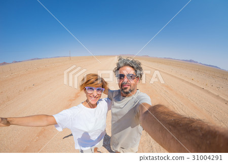 Adult couple taking selfie on gravel road 31004291