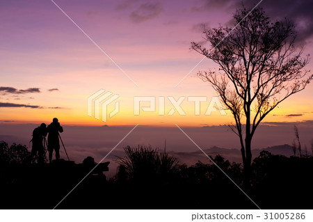 Young men silhouette taking photos about landscape Young men silhouette taking photos about landscape 31005286