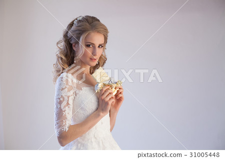 bride in wedding dress holding a chocolate 31005448