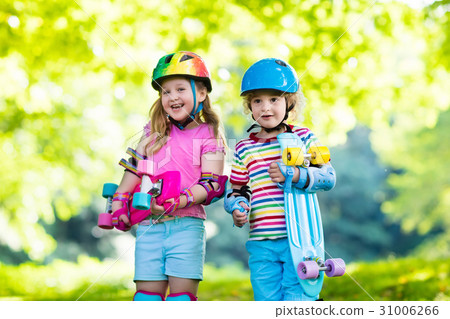 Children riding skateboard in summer park Children riding skateboard in summer park 31006266