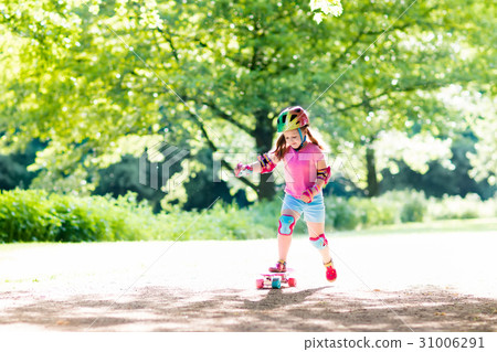 Child riding skateboard in summer park 31006291