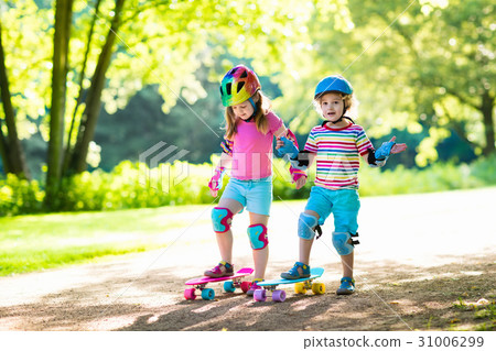 Children riding skateboard in summer park 31006299
