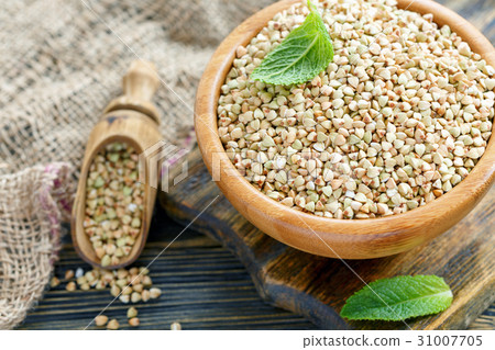 Bowl with green buckwheat and mint leaf close up. Bowl with green buckwheat and mint leaf close up. 31007705