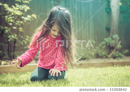 Little girl sitting in the garden 31008642