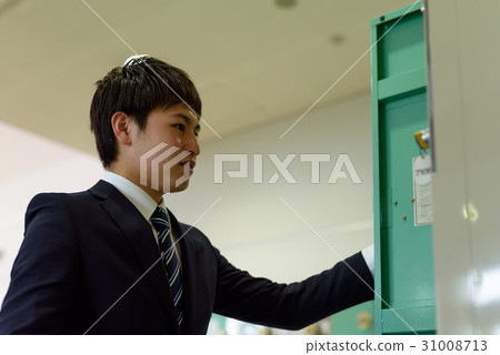 A businessman using an airport locker A businessman using an airport locker 31008713