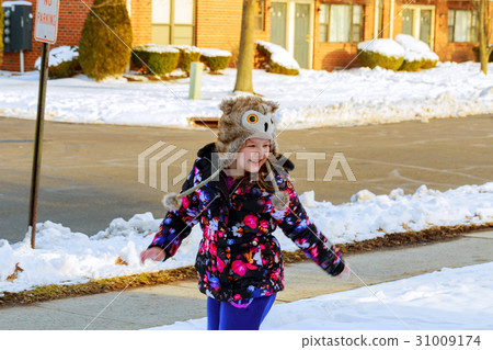 Little girl shoveling snow on home drive way. 31009174