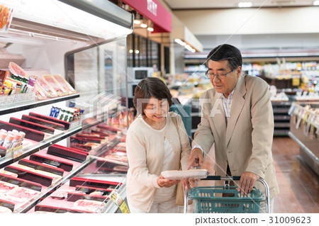 Senior couple buying meat at supermarket 31009623
