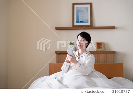 在床上玩智能手機的女人 在床上玩智能手機的女人 31010727