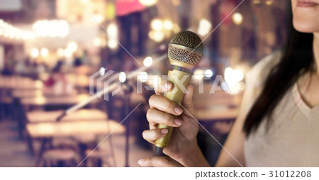Woman holding microphone  in pub and restaurant 31012208