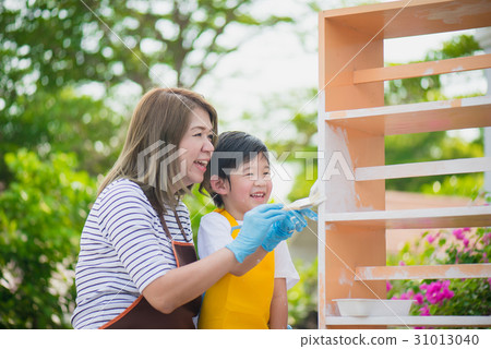 Asian mother and son painting wooden shelf  31013040