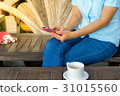 Hand holding mobile phone and a cup of coffee. 31015560