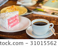 A cup of  coffee and a piece of cake. 31015562
