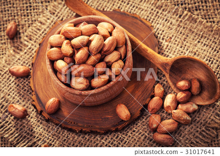 Peeled peanuts in a wooden bowl on an old burlap Peeled peanuts in a wooden bowl on an old burlap 31017641
