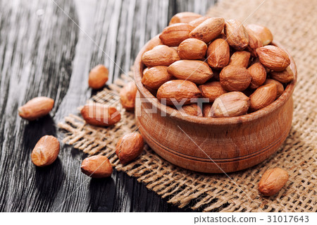 Peeled peanuts in a wooden bowl on an old burlap 31017643
