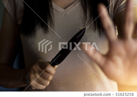 Woman holding knife, defending from attact 31023258