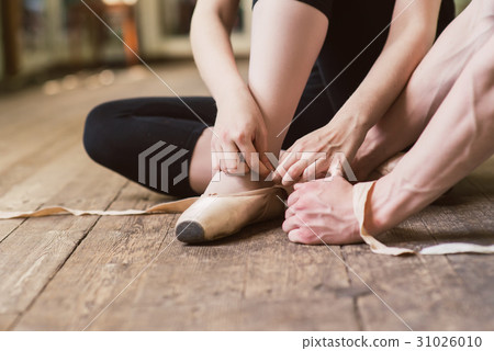 Ballerina putting on her ballet shoes 31026010