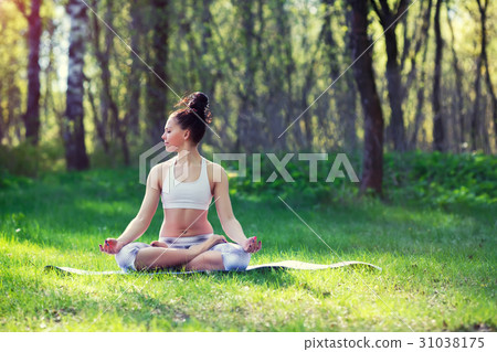 Young woman doing yoga exercises in the summer 31038175