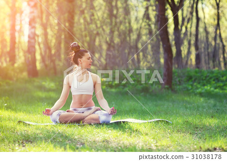Young woman doing yoga exercises in the summer 31038178