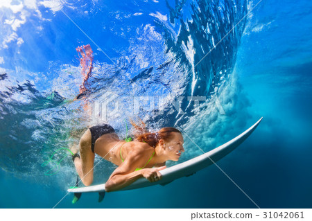 Active girl in bikini in dive action on surf board 31042061