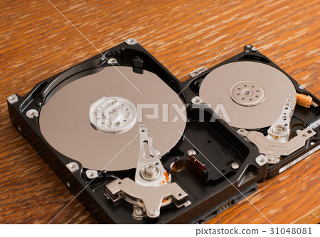 Disassembled hard drives on a wooden surface 31048081