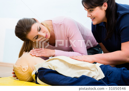 Group of women in first aid class exercising 31050546