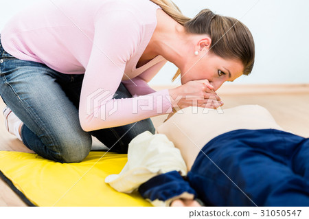 Woman training mouth-to-mouth breath donation on 31050547