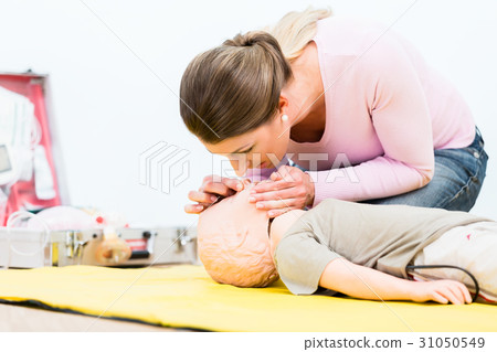 Woman in first aid course practicing revival of 31050549