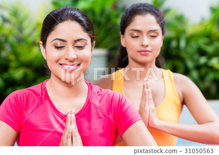 Two women in lotus position during yoga practice Two women in lotus position during yoga practice 31050563