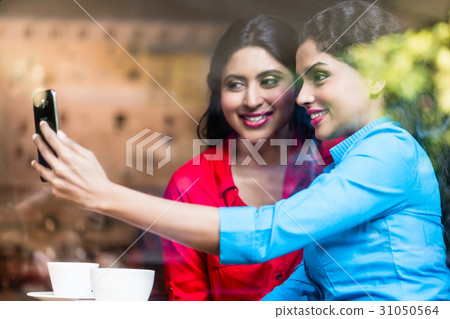Customers in Indian cafe taking selfie 31050564