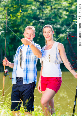 Fishing couple, man and woman, on lake being proud Fishing couple, man and woman, on lake being proud 31050585