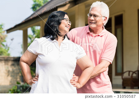 Senior man assisting his wife during warming up Senior man assisting his wife during warming up 31050587