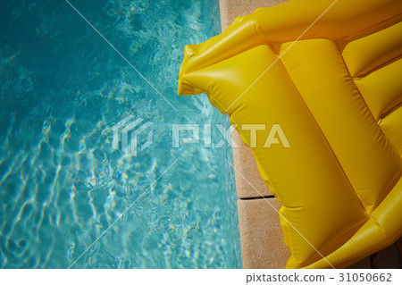 yellow air mattress swimming in a shiny blue swimm 31050662