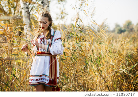 Young girl on the summer field in national clothes Young girl on the summer field in national clothes 31050717