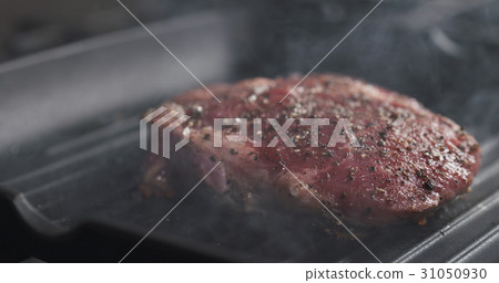 cooking rib eye steak on grill pan 31050930