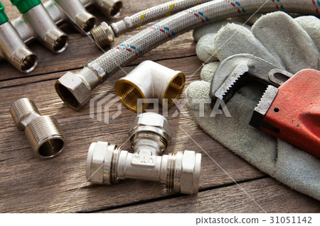 Set of plumbing and tools on the wooden table 31051142